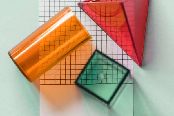 cuboid cylinder and triangle prism shaped objects on graphed paper