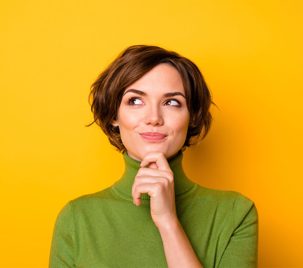 Woman with medium brunette hair with her hand on her chin thinking