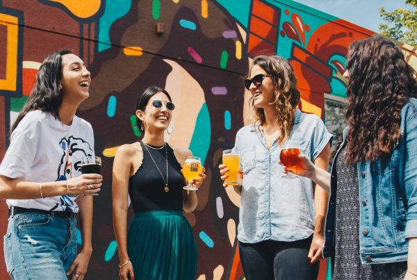 4 female friends chatting whilst enjoying an alcoholic beverage