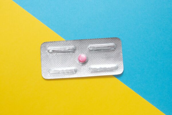 Contraceptive pill in a packet against a yellow and light blue background