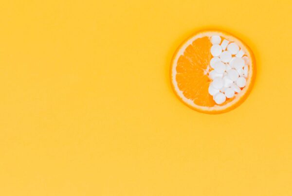 Yellow background with an orange segment half covered in pills