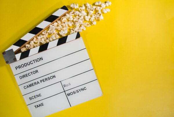 A directors clapper board on a bright yellow background